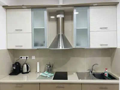a kitchen with white cabinets and a stainless steel hood at Bluebay Cozy Aparment in Athens