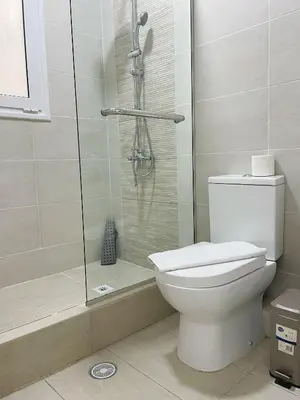 a bathroom with a toilet and a glass shower at Bluebay Cozy Aparment in Athens