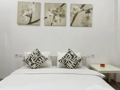 a bedroom with a white bed with four pictures on the wall at Bluebay Cozy Aparment in Athens
