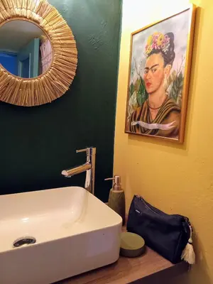 a bathroom with a sink and a painting of a woman at The Happy Town House , 300m from the metro station in Athens