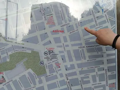 a hand pointing at a map of a city at The Happy Town House , 300m from the metro station in Athens