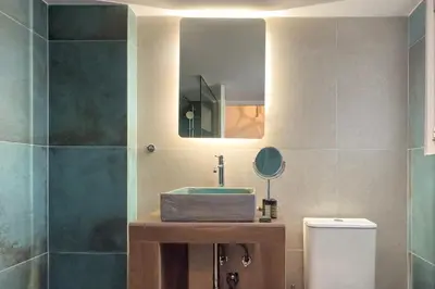 a bathroom with a sink and a mirror at Phaedrus Living Kallithea Heights Residence in Athens