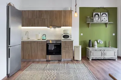 a kitchen with a stainless steel refrigerator and wooden cabinets at Phaedrus Living Kallithea Heights Residence in Athens