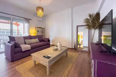 a living room with a purple couch and a table at Phaedrus Living Kallithea Heights Residence in Athens