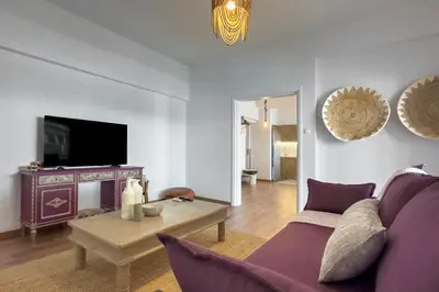 a living room with a purple couch and a table at Phaedrus Living Kallithea Heights Residence in Athens