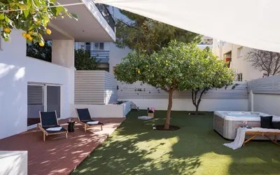 a patio with a tree and two chairs and a table at Athena's Lemon Grove Glyfada in Athens