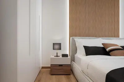 a bedroom with a bed and a lamp on a night stand at Athena's Lemon Grove Glyfada in Athens