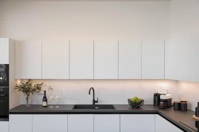 a kitchen with white cabinets and a sink at Athena's Lemon Grove Glyfada in Athens