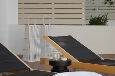 a patio with two chairs and a table with a candle at Athena's Lemon Grove Glyfada in Athens