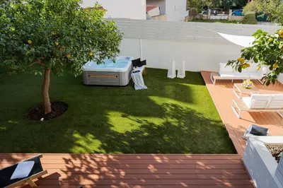 a yard with a tree and a couch and chairs at Athena's Lemon Grove Glyfada in Athens
