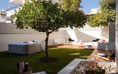 a small garden with a tree in the middle at Athena's Lemon Grove Glyfada in Athens