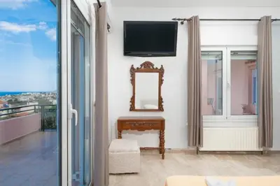 a living room with a mirror and a tv on the wall at Spacious house with seaview in Porto Rafti