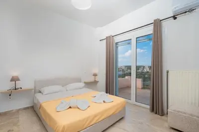 a bedroom with a bed and a large window at Spacious house with seaview in Porto Rafti