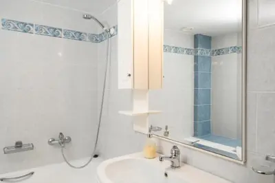 a white bathroom with a shower and a sink at Spacious house with seaview in Porto Rafti
