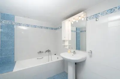 a white bathroom with a sink and a tub and a sink at Spacious house with seaview in Porto Rafti
