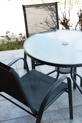 a white table and a black chair next to a table at Spacious house with seaview in Porto Rafti