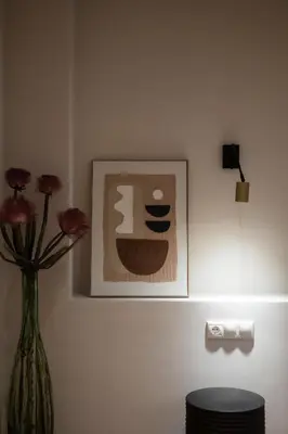 a vase with flowers in a room with a picture at Acropolis Soul in Athens