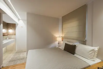 a white bedroom with a bed and a sink at Acropolis Soul in Athens