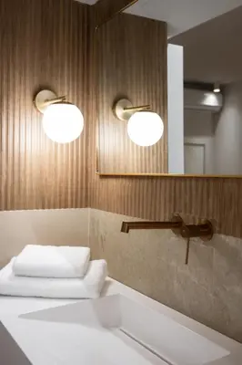 a bathroom with two lights and a sink and a mirror at Acropolis Soul in Athens
