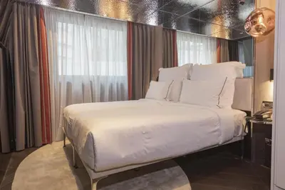 a large white bed in a room with a window at Adia Aluma Athens, Curio Collection By Hilton in Athens