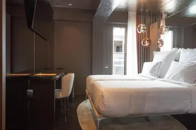 a bedroom with a bed and a table and a desk at Adia Aluma Athens, Curio Collection By Hilton in Athens