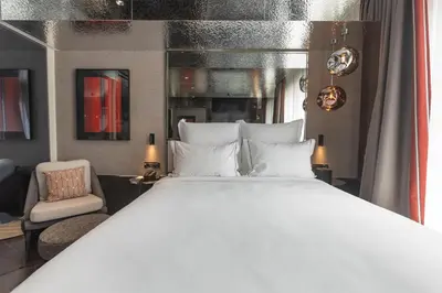 a bedroom with a large white bed and a chair at Adia Aluma Athens, Curio Collection By Hilton in Athens