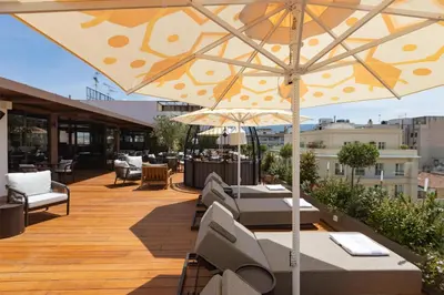 a patio with tables and chairs and an umbrella at Adia Aluma Athens, Curio Collection By Hilton in Athens
