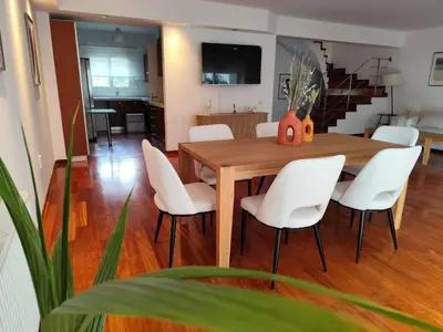 a dining room with a wooden table and white chairs at Adelos II Glow Villa 5BR 360m -Elevator-Rooftop in Athens