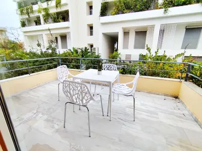 a patio with a table and chairs on a balcony at Adelos II Glow Villa 5BR 360m -Elevator-Rooftop in Athens