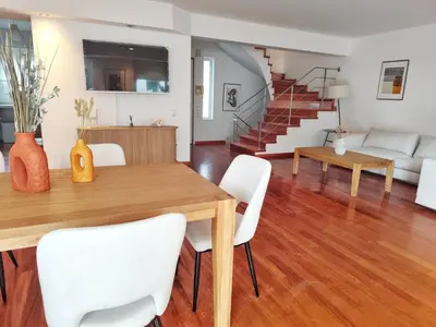 a dining room and living room with a table and chairs at Adelos II Glow Villa 5BR 360m -Elevator-Rooftop in Athens