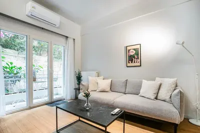 a living room with a couch and a table at Lyndon Deluxe Studio - Athens Modern Escape in Athens