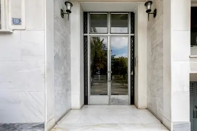 an entrance to a white building with a glass door at Lyndon Deluxe Studio - Athens Modern Escape in Athens