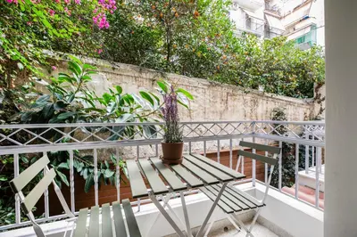 a table and chairs on a balcony with plants at Lyndon Deluxe Studio - Athens Modern Escape in Athens