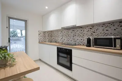 a kitchen with white cabinets and a microwave at Seaside Elegance Brand New 2BD Luxury Stay in Athens
