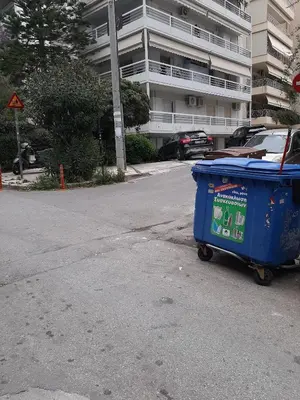 a blue trash can sitting on the side of a street at Seaside Elegance Brand New 2BD Luxury Stay in Athens