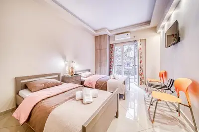 a bedroom with two beds and a table and chairs at So36 Filoxenia Place Like Home Kolonaki- next to metro and center in Athens