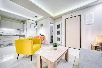 a living room with a yellow chair and a table at So36 Filoxenia Place Like Home Kolonaki- next to metro and center in Athens