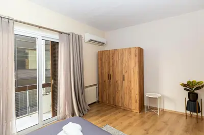 a bedroom with a bed and a wooden door at Central Athens Charm in Athens