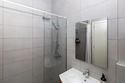 a bathroom with a shower and a sink and a mirror at Central Athens Charm in Athens