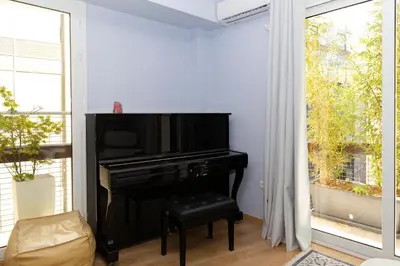 a black piano in a living room with a window at Central Athens Charm in Athens