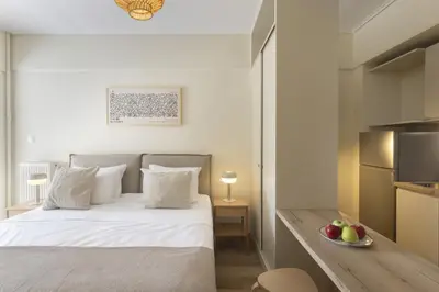 a bedroom with a bed and a table with a bowl of fruit at Renovated Studio with Sea View in Palaio Faliro in Athens