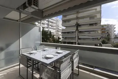 a table on the balcony of a building at Renovated Studio with Sea View in Palaio Faliro in Athens