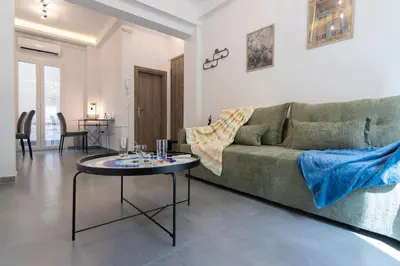 a living room with a green couch and a table at Daedalus Minimal 1bedroom Bliss in Athens