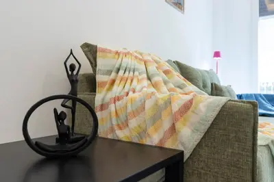 a table with a blanket on a couch at Daedalus Minimal 1bedroom Bliss in Athens