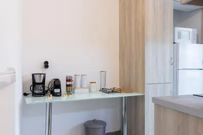 a kitchen with a counter with a white refrigerator at Daedalus Minimal 1bedroom Bliss in Athens