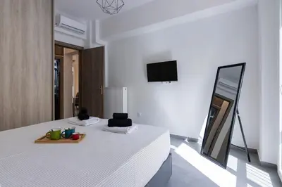 a white room with a bed and a mirror at Daedalus Minimal 1bedroom Bliss in Athens
