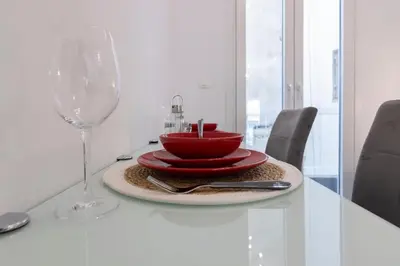 a table with a red bowl and a wine glass at Daedalus Minimal 1bedroom Bliss in Athens