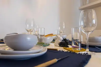 a table with plates and wine glasses on it at Culture and Luxury 2bed Flat with Acropolis Views in Athens