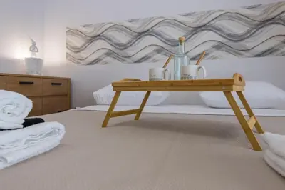 a wooden table with cups and bottles on a bed at Culture and Luxury 2bed Flat with Acropolis Views in Athens