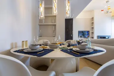 a white dining room table with chairs and glasses at Culture and Luxury 2bed Flat with Acropolis Views in Athens